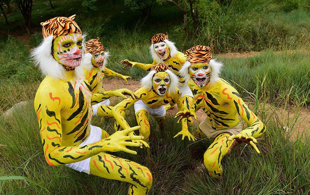 School kids, with painted bodies, pose during an event of Save the Tiger campaign at Lalbagh in Bengaluru.