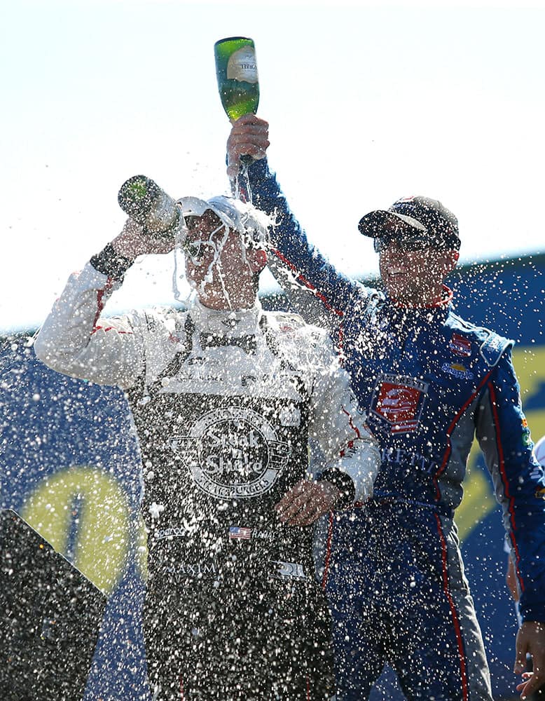 Graham Rahal is doused with champagne by Justin Wilson, of England, after winning the IndyCar Honda Indy 200 auto racing at Mid-Ohio Sports Car Course in Lexington, Ohio.