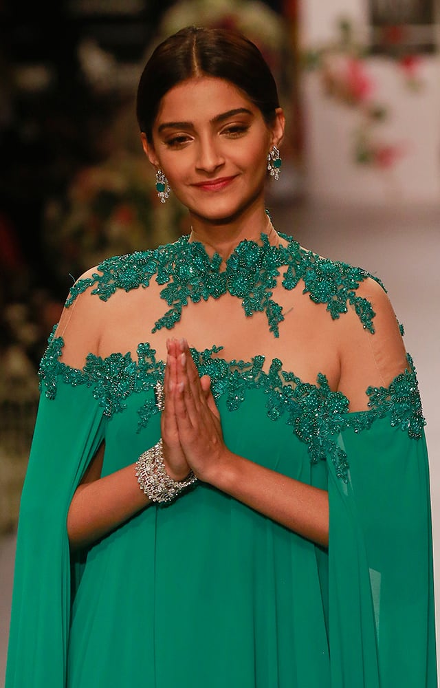 Sonam Kapoor greets as she walks the ramp during a fashion show at the India International Jewellery Week in Mumbai.