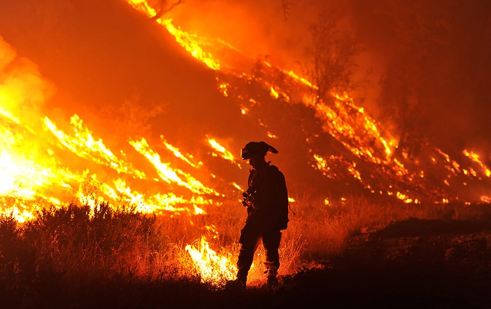 CalFire firefighter Bo Santiago lights a backfire as the Rocky fire burns near Clearlake, Calif.. The fire has charred more than 60,000 acres and destroyed at least 24 residences.