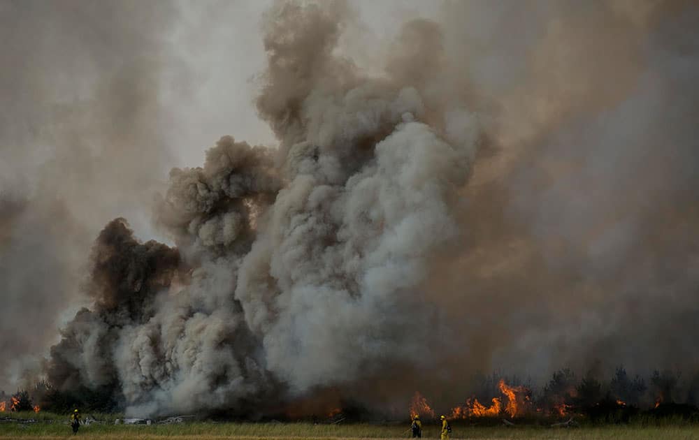 firefighters work to contain a brush fire near the South Jetty at Fort Stevens State Park in Warrenton, Ore. 