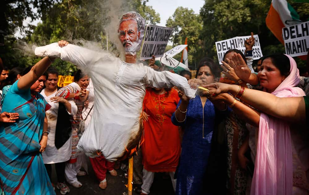 India's opposition Congress party workers burn an effigy of Prime Minister Narendra Modi outside the office of the ruling Bharatiya Janata Party (BJP) in New Delhi, India.