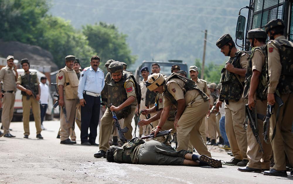 Paramilitary soldiers check the body of a suspected rebel after a gunbattle on the Jammu- Srinagar highway at Narsoo Nallah, near Udhampur.