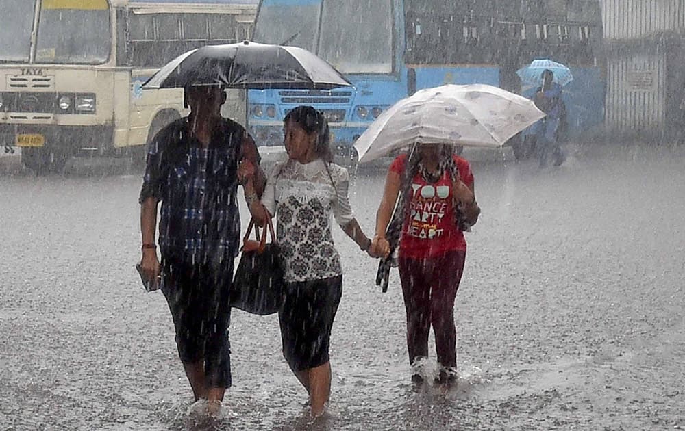 People crossing road during heavy rain in Kolkata.