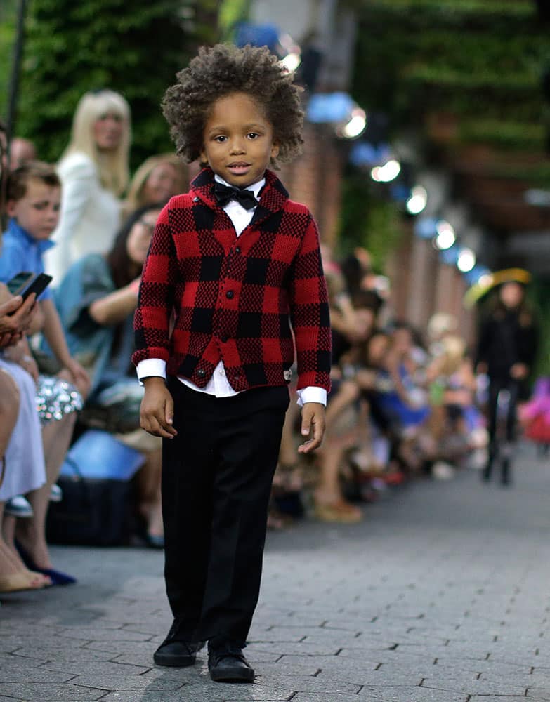 A young model stops and turns at the end of the runway during a Ralph Lauren children's Fall fashion show.