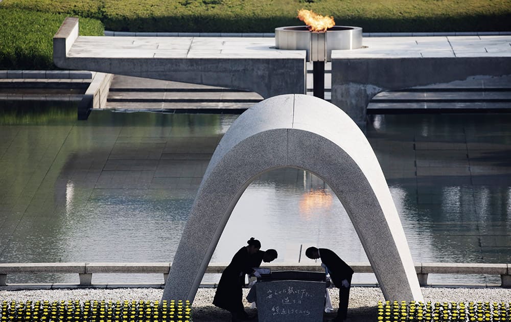 Kazumi Matsui, mayor of Hiroshima, and the family of the deceased bow before they place the victims list of the Atomic Bomb at Hiroshima Memorial Cenotaph during the ceremony to mark the 70th anniversary of the bombing at the Hiroshima Peace Memorial Park in Hiroshima, western Japan.