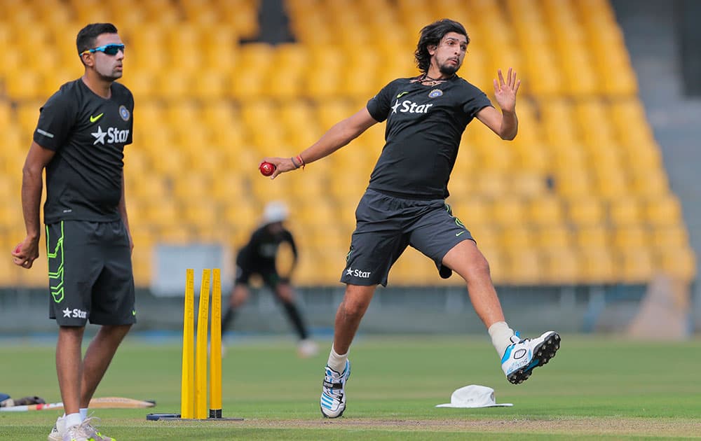 Ishant Sharma delivers a ball as Ravichandran Ashwin watches before a three day practice match against Sri Lankan Board Presidents XI in Colombo, Sri Lanka.