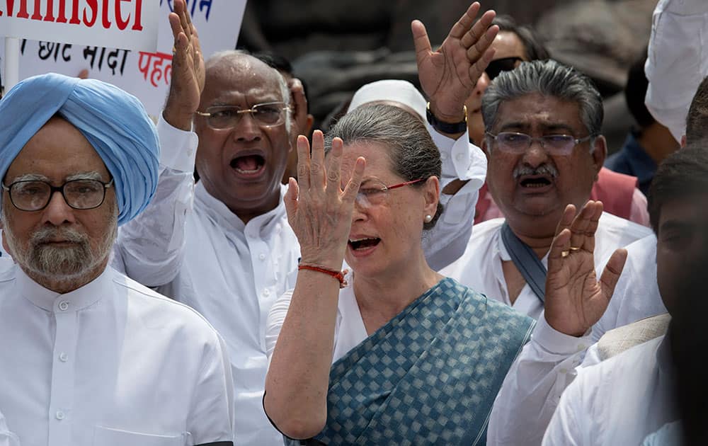 India's former prime minister Manmohan Singh, joins opposition Congress party president Sonia Gandhi and other opposition lawmakers shouting slogans during a protest in the Parliament premises in New Delhi, India.