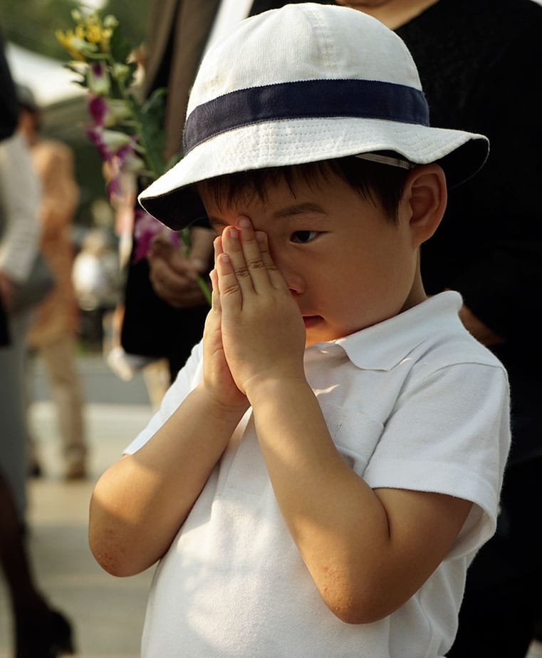A BOY PRAYS FOR THE ATOMIC BOMB VICTIMS IN FRONT OF THE CENOTAPH AT THE HIROSHIMA PEACE MEMORIAL PARK IN HIROSHIMA, WESTERN JAPAN.