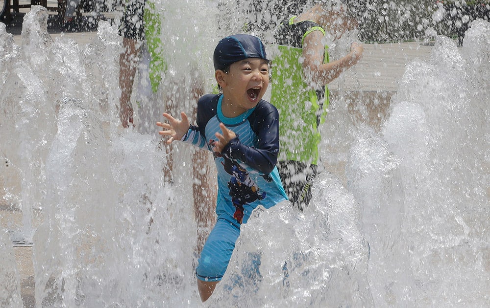 A boy plays in a fountain to beat the summer heat in Seoul, South Korea.