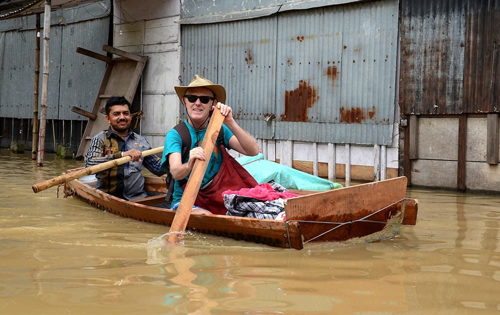 A foreigner rows a boat on a road submerged due to floodwater, at Mayapur in Nadia district of West Bengal.