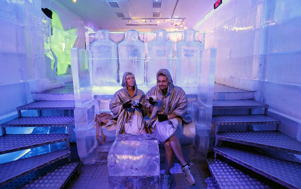 A couple seeking shelter from hot weather enjoy cold drinks inside an ice pub in Prague, Czech Republic.