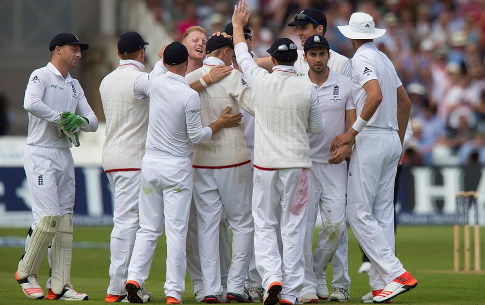 England's Ben Stokes celebrates with teammates after taking the wicket of Australia's Chris Rogers caught by Joe Root for 52 on the second day of the fourth Ashes test cricket match between England and Australia at Trent Bridge cricket ground in Nottingham, England.