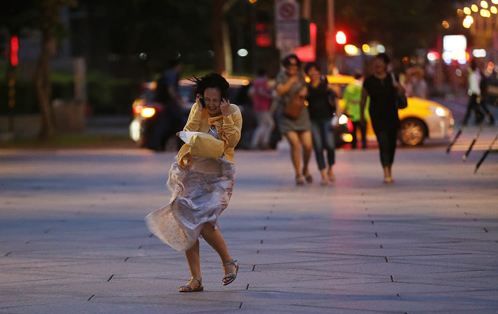 A woman is caught in strong gusts from Typhoon Soudelor in Taipei, Taiwan.