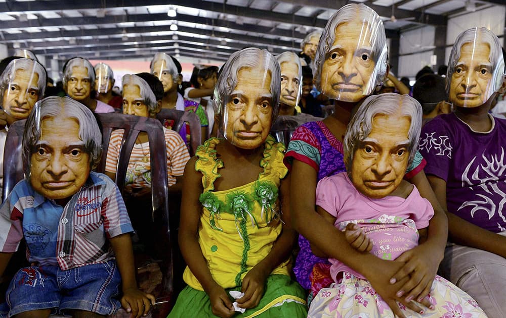 Children wear masks of former President A P J Abdul Kalam during a programme to pay tributes to him, in Chennai.