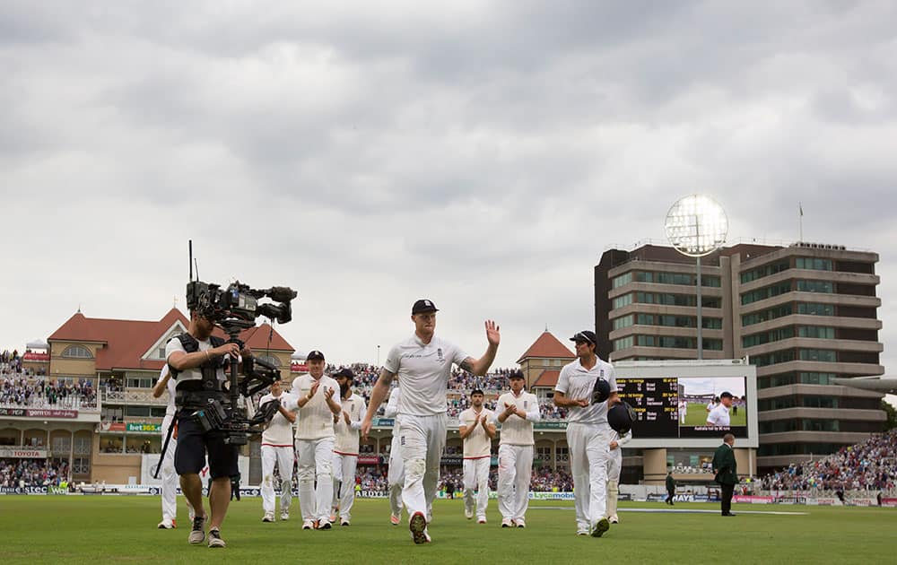 England's Ben Stokes, centre, who took five wickets in the day waves as he walks from the pitch as bad light stops play on the second day of the fourth Ashes test cricket match between England and Australia at Trent Bridge cricket ground in Nottingham, England.