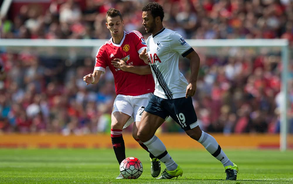 Manchester United's Morgan Schneiderlin, left, fights for the ball against Tottenham's Mousa Dembele during the English Premier League soccer match between Manchester United and Tottenham at Old Trafford Stadium, Manchester, England.