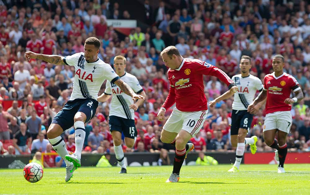 Tottenham's Kyle Walker, left, scores an own goal as he tries to clear the ball away from Manchester United's Wayne Rooney during the English Premier League soccer match between Manchester United and Tottenham at Old Trafford Stadium, Manchester, England.