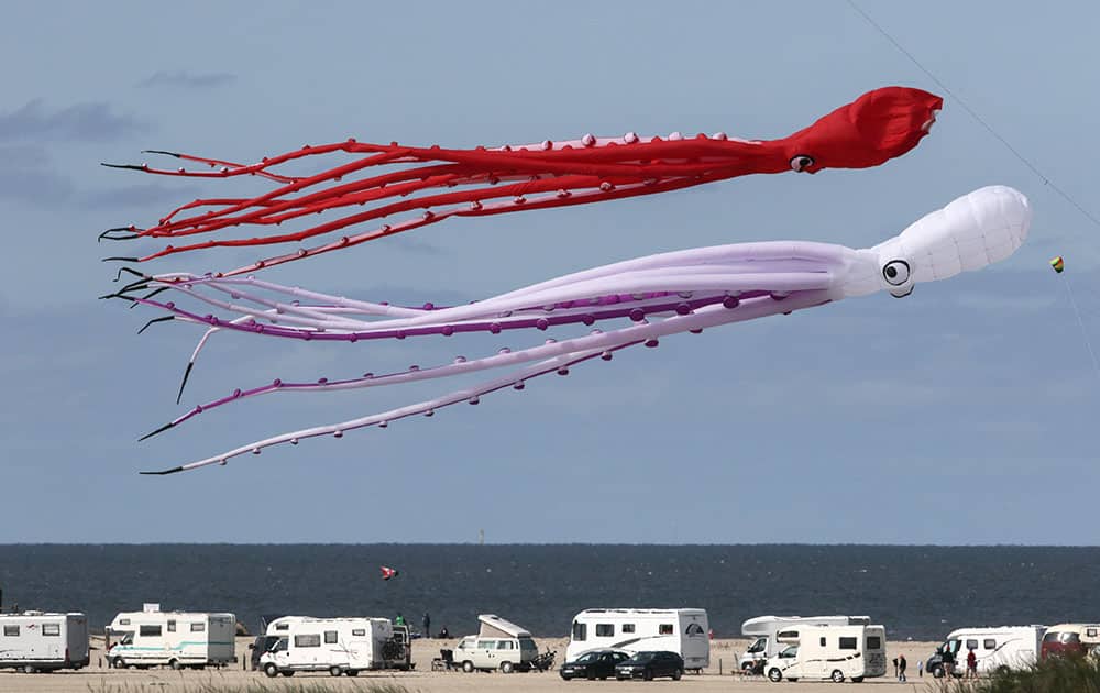 Kites shaped like squids fly over a windy beach in St. Peter-Ording at the North Sea in Germany.
