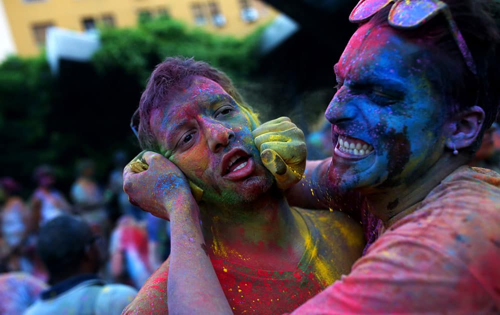 A reveler puts some colored powder in a friend's face during the Monsoon Holi Festival, in Madrid, Spain.