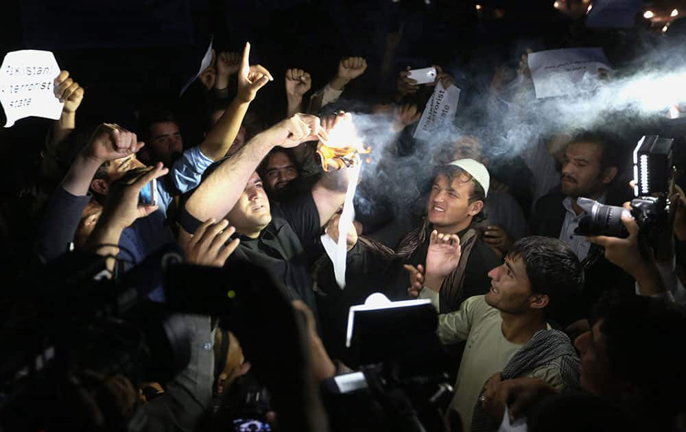 Afghan civil society members burn Pakistani currency to show their anger against Pakistan, that they say supports terrorist groups, during a vigil ceremony for victims of Fridays attacks in Kabul, Afghanistan.