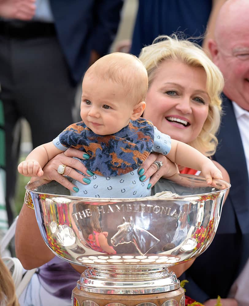 Christina Takter holds her grandson Austin in the Hambletonian Cup after Takter's husband, trainer Jimmy Takter, won the Hambletonian harness horse race with Pinkman in East Rutherford, N.J. 