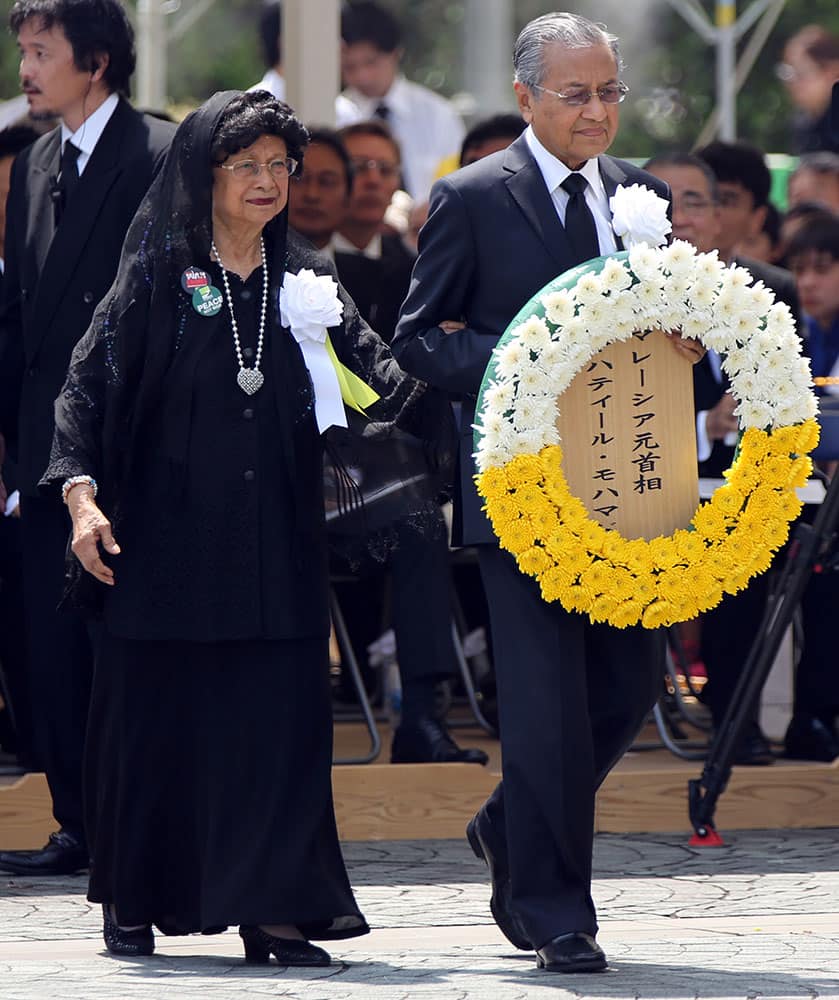 Former Malaysian Prime Minister Mahathir Mohamad, right, and his wife Siti Hasmah, left, bring a wreath during a ceremony to mark the 70th anniversary of the atomic bombing in Nagasaki, southern Japan.