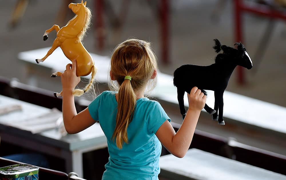 Khiya Edwards, 7, celebrates the winner of the seventh race with her horses at Ellis Park in Henderson, Ky. 