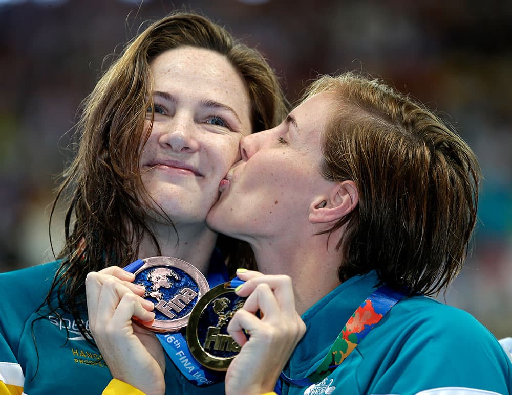 Australia's Bronte Campbell, right, holds her gold medal as she kisses her sister and bronze medalist Cate Campbell after winning the women's 100m freestyle final at the Swimming World Championships in Kazan, Russia.