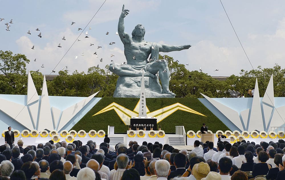 Doves fly over the Statue of Peace during a ceremony at Nagasaki Peace Park in Nagasaki.