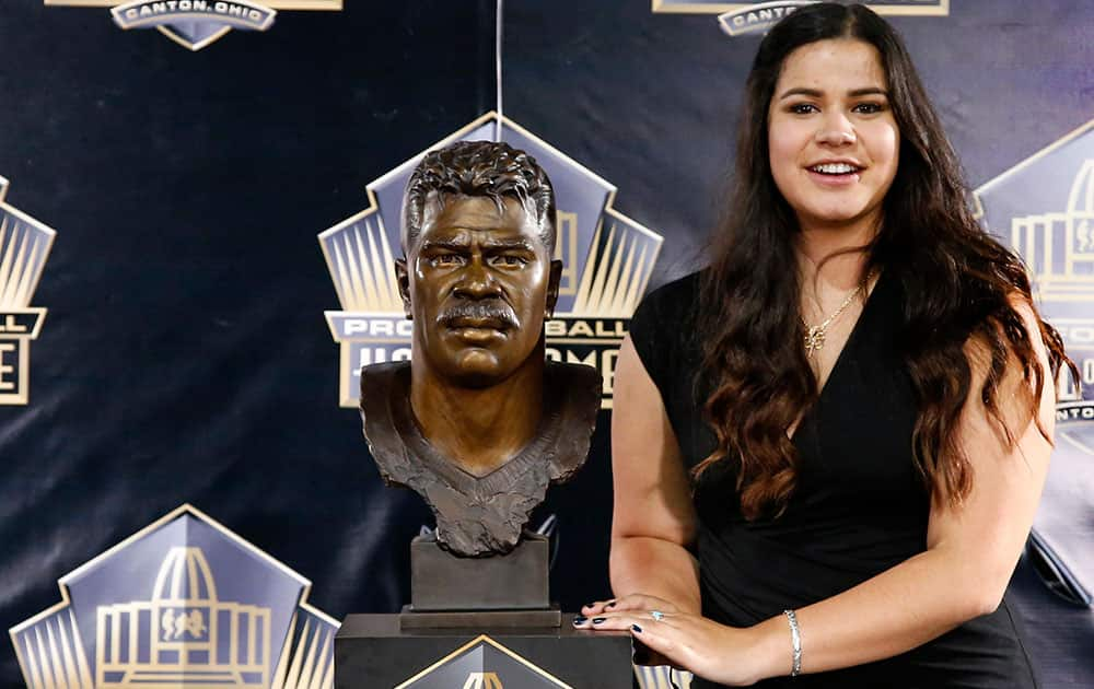 Sydney Seau, aughter of former NFL player Junior Seau, poses with a bust of her father during inductions at the Pro Football Hall of Fame in Canton, Ohio.