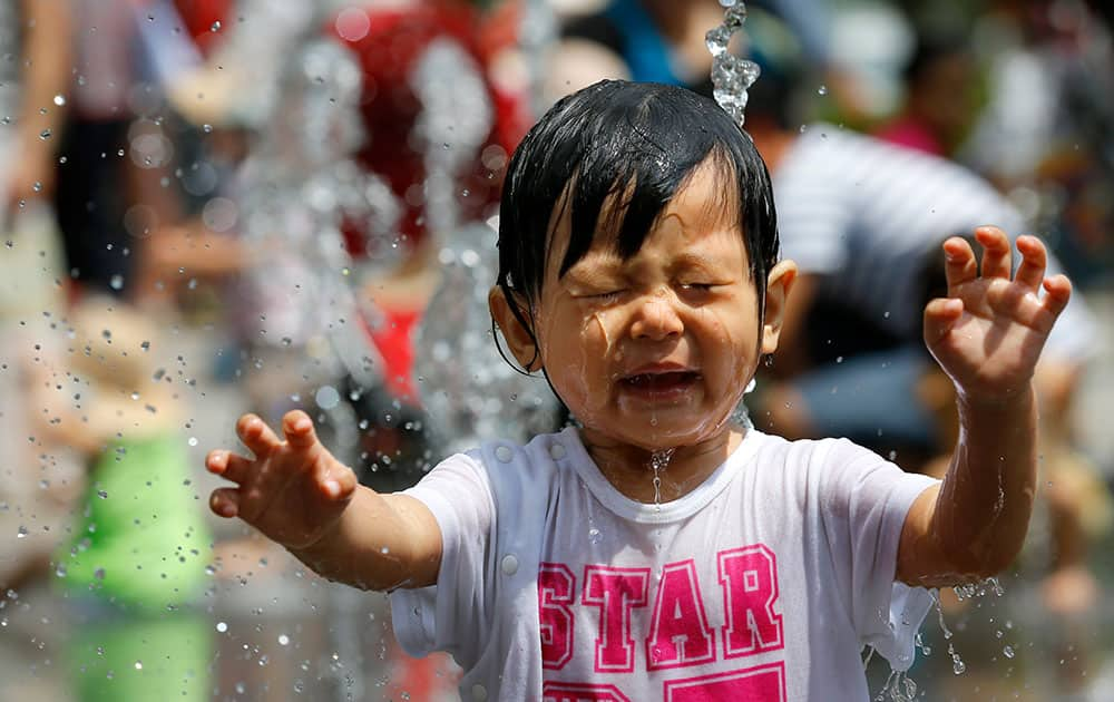 A girl plays in a water fountain at Soramachi shopping complex in Tokyo.