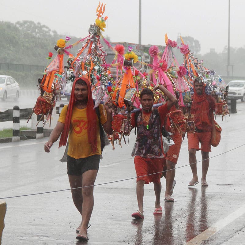 Kanwadiyas on their way to carry the holy water of River Ganga during the downpour, in Gurgaon.