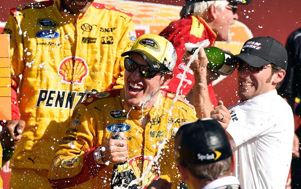 Joey Logano celebrates in the victory lane after winning a NASCAR Sprint Cup series auto race at Watkins Glen International in Watkins Glen. N.Y. 