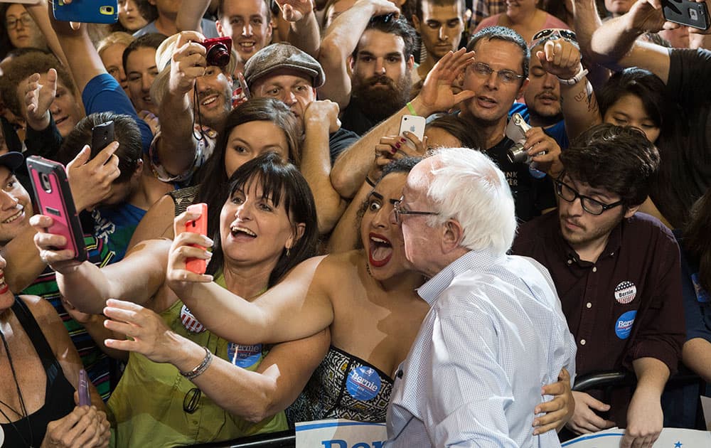 Naomi Scott, center, of McMinnville, Ore., takes a picture with Democratic presidential candidate Sen. Bernie Sanders, I-Vt., at a rally, at the Moda Center in Portland, Ore.