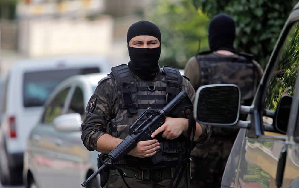 Masked Turkish police officers secure a road leading to the U.S. Consulate building in Istanbul.