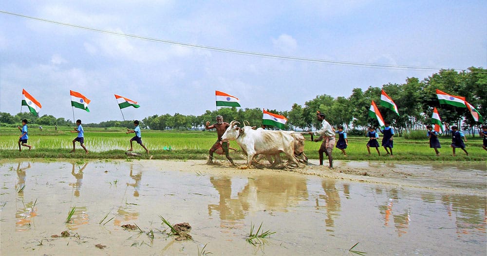 School children run with Tricolours in a village ahead of Independence Day celebrations at Parui in Birbhum district of West Bengal.