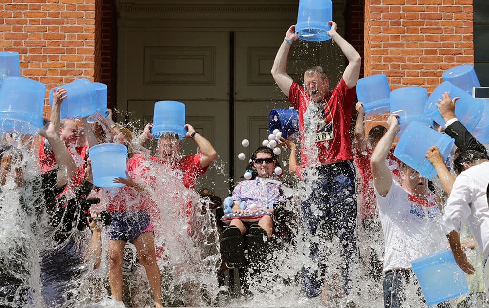 Massachusetts Gov. Charlie Baker, right center, and Lt. Gov. Karyn Polito, third from left, participate in the Ice Bucket Challenge with its inspiration Pete Frates, seated in center, to raise money for ALS research at the Statehouse in Boston.