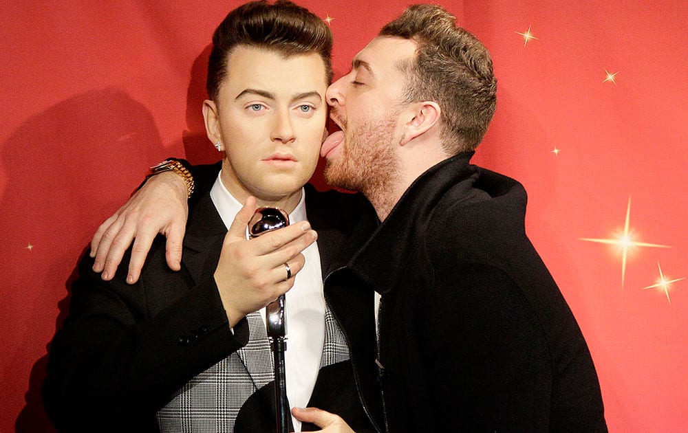 Singer Sam Smith, right, licks the face of his wax figure at Madame Tussauds wax museum in San Francisco.