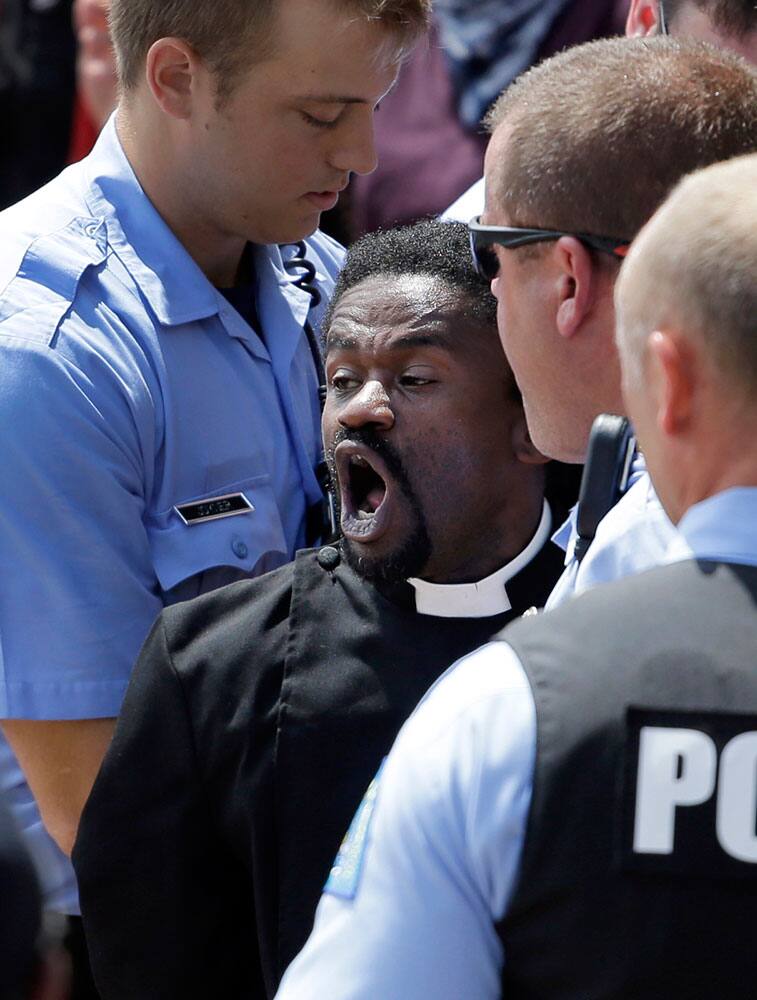 Protest organizer the Rev. Osagyefo Sekou is arrested by police outside the Thomas F. Eagleton Federal Courthouse in St. Louis.