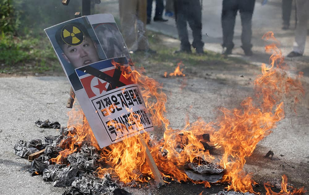 Members of South Korean conservative group burn a picture of North Korean leader Kim Jong Un and North Korea's flag during a rally denouncing the North Korea at the Imjingak Pavilion near the border village of Panmunjom, which has separated the two Koreas since the Korean War, in Paju, north of Seoul, South Korea.