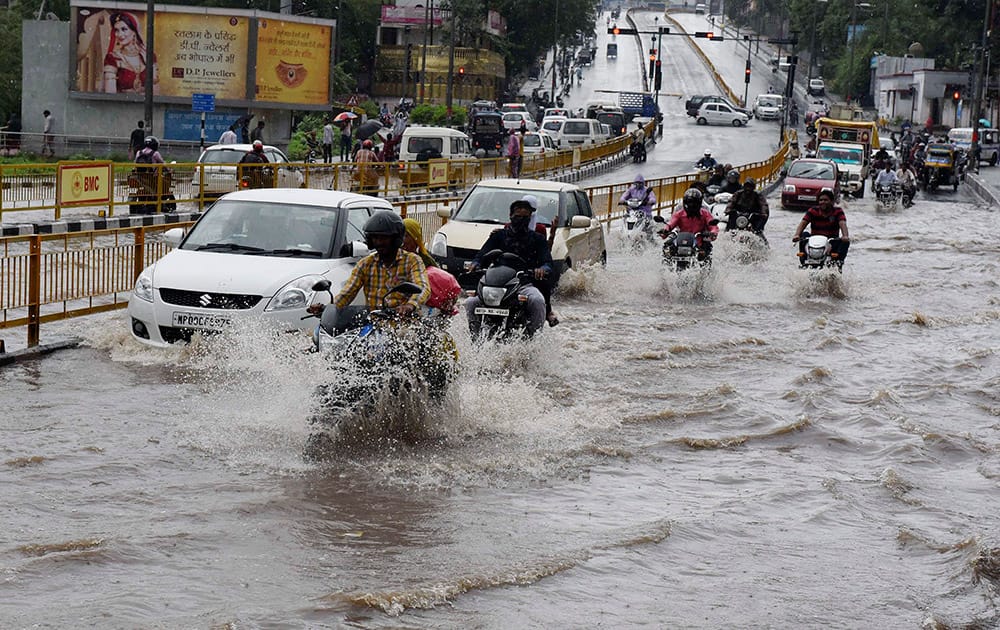 Vehicles wade through a water logged street following heavy rains in Bhopal.