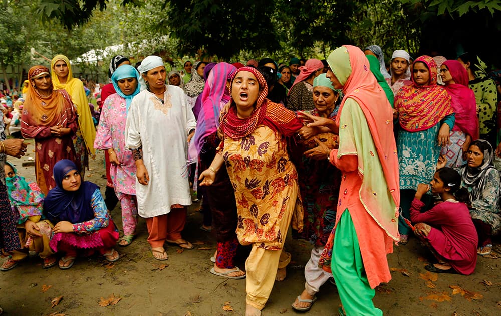Unidentified women comfort the mother of civilian Bilal Ahmad, as she wails during a funeral procession at Awantipora, from Srinagar.
