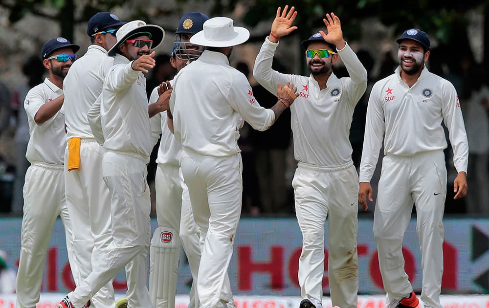 Virat Kohli, celebrates with teammates the dismissal of Sri Lanka's Kaushal Silva their first cricket test match in Galle, Sri Lanka.