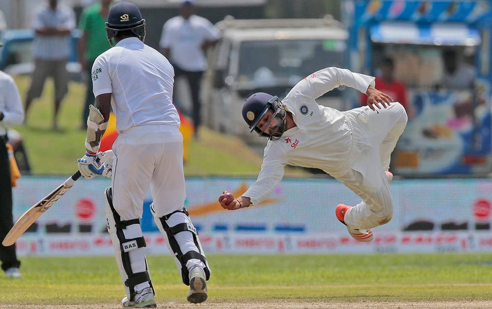 Rohit Sharma successfully completes a catch to dismiss Sri Lanka's Angelo Mathews during the first cricket test match between India and Sri Lanka in Galle.