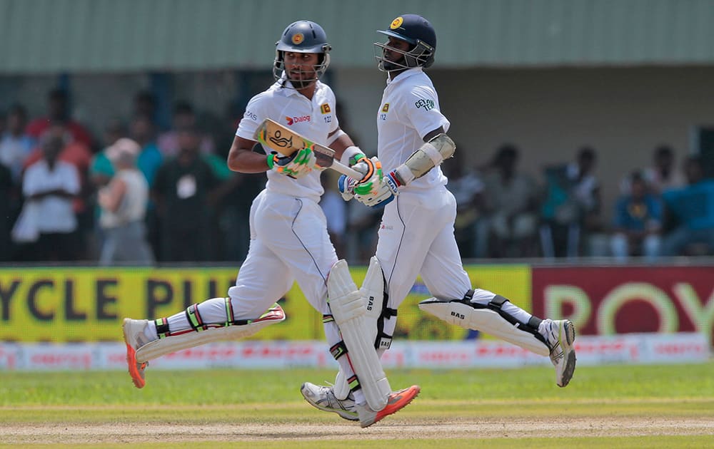 Dinesh Chandimal and Angelo Mathews run between wickets during the first cricket test match between India and Sri Lanka in Galle, Sri Lanka.