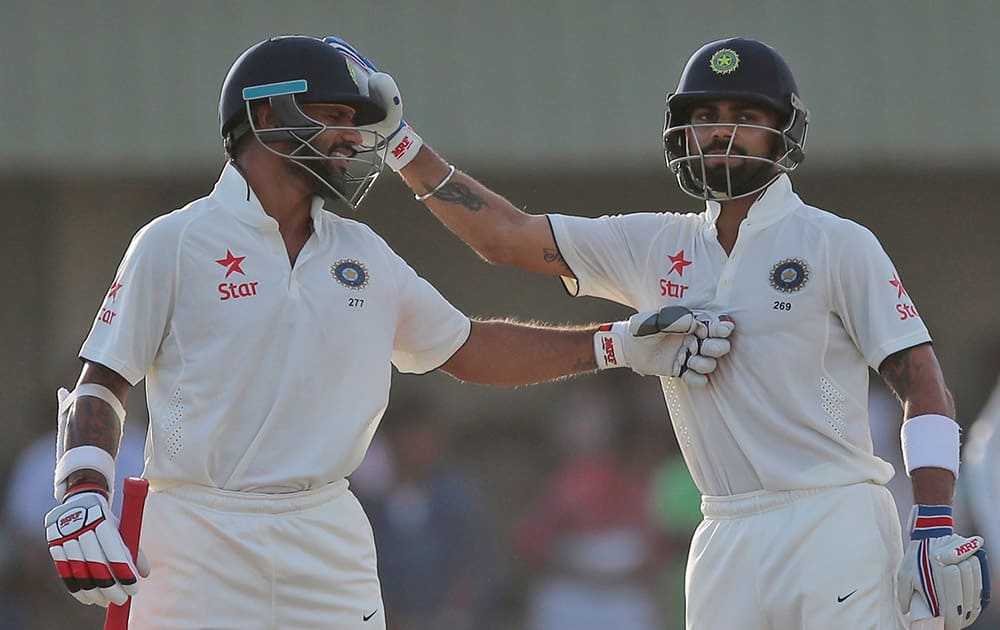 Virat Kohli and Shikar Dhawan cheer each other as they complete their hundred runs partnership during the first cricket test match between India and Sri Lanka in Galle, Sri Lanka.