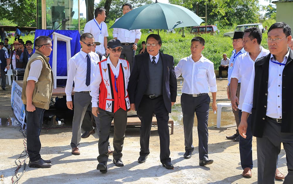 An aide holds an umbrella as Thuingaleng Muivah, leader of the Isak-Muivah faction of the National Socialist Council of Nagaland, walks at a civic reception accorded to him in Dimapur. Muivah, leader of a key rebel group in the country's insurgency-wracked northeast returned to Nagaland Wednesday after he signed a peace treaty with India's government on August 3.