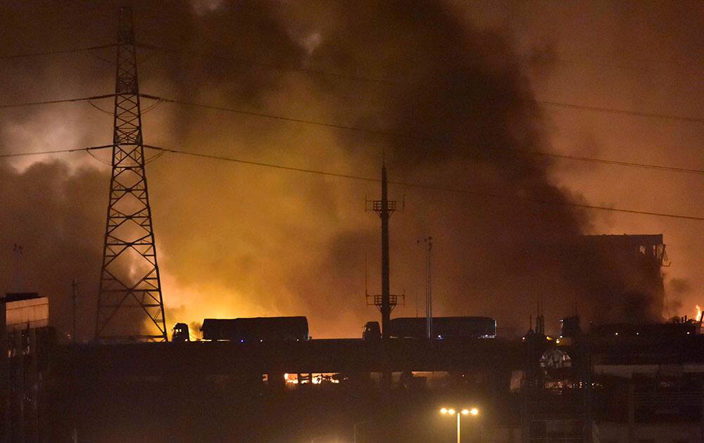 trucks pass a bridge near the site of explosions in the Binhai New Area in northeastern China's Tianjin municipality.