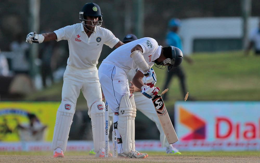 Sri Lankan batsman Dimuth Karunarathne looks back at his wicket after being bowled during the second day of the first test cricket match between Sri Lanka and India in Galle, Sri Lanka.